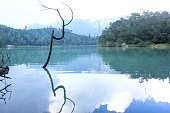 the view of the colorful lake reflecting the clouds in Dieng