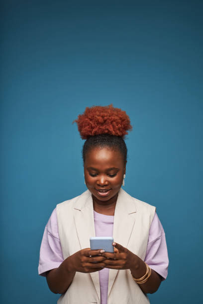 istock Minimal black woman using smartphone against blue background 1480238728