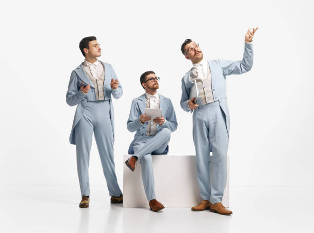 shot of three men, friends wearing old style clothes and discuss things emotionally over white studio background. business partners - real people blue white friendship imagens e fotografias de stock