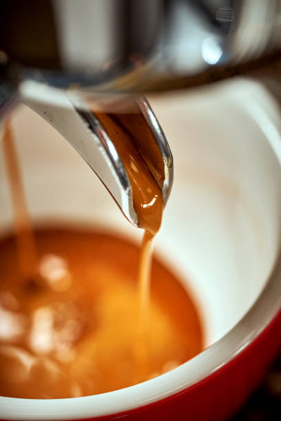 istock Preparation of espresso in a coffee machine. Hot coffee is poured into a cup 1480244897