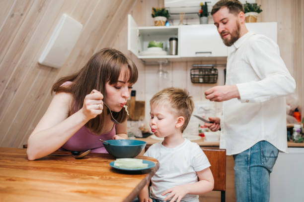 istock Happy child eats pasta in the kitchen with her family 1480248280