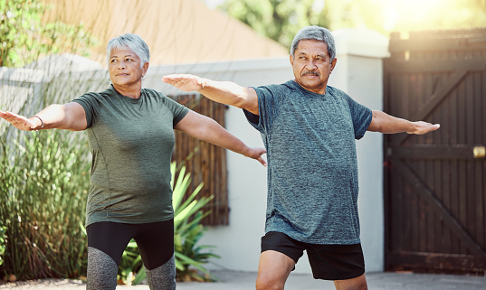 Exercise, yoga and health with a senior couple outdoor in their garden for a workout during retirement. Fitness, pilates and lifestyle with a mature man and woman training together in their backyard