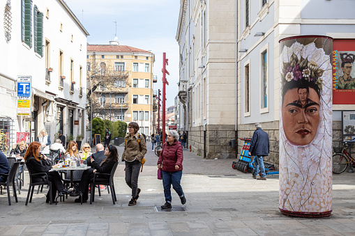 Padua, Veneto, Italy - Mar 11th, 2023: View of pedestrians, cafes and street art on the streets of Padua city center