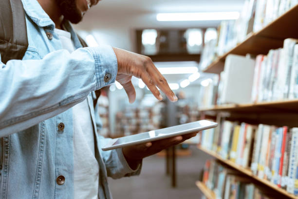 istock Touch screen, education or black man hand on tablet in library for research, advertising or project management. Digital or university student with tech for learning, scholarship study or web search 1480249274