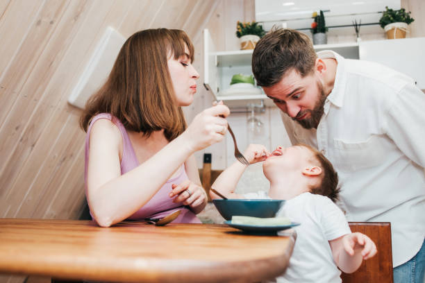 istock Mother with father feeding the child in the kitchen with pasta 1480249564