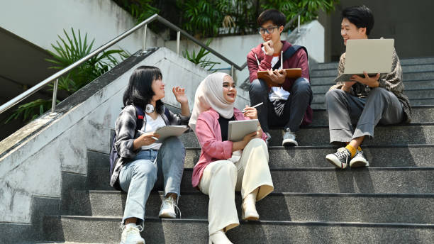 istock Happy diverse group of college students sitting on stairs working together on study project. Education and youth lifestyle concept. 1480250213