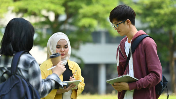 istock Group of students talking to each other after classes while walking in university outdoors. Youth lifestyle and community. 1480250219