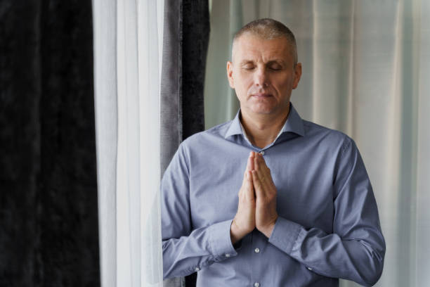 istock A man stands near the window doing relaxing breathing exercises. 1480250534
