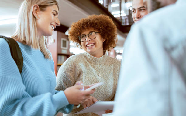 istock Happy, education or students with phone in library for research, collaboration or project management. Smile, documents or university people group on tech for learning, scholarship study or web search 1480254695