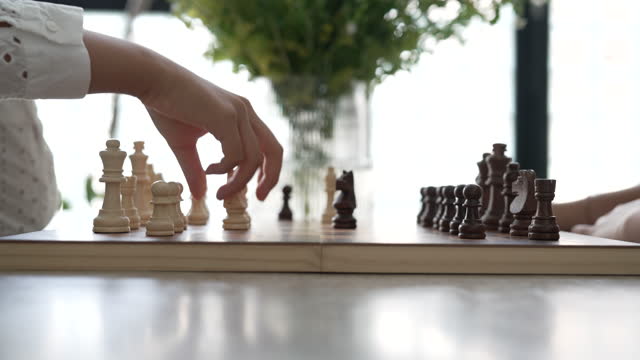 View of sisters playing chess at home