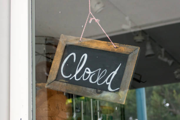 istock Closed sign hanging in store window 1480259346