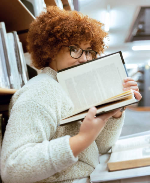 istock Books, education or black woman in a library reading for knowledge or development for future growth. Scholarship, portrait or focused school girl studying or learning college information on page 1480261816