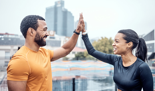 Couple of friends, high five and exercise in city for workout success, team support and marathon winner. Happy athletes, sports motivation and celebration of achievement, wellness and fitness goals