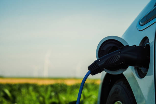 istock Automobile charging against blurred windmills on field 1480262832