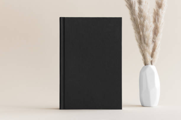 istock Black book mockup with a pampas decoration on the soft yellow background. 1480264430