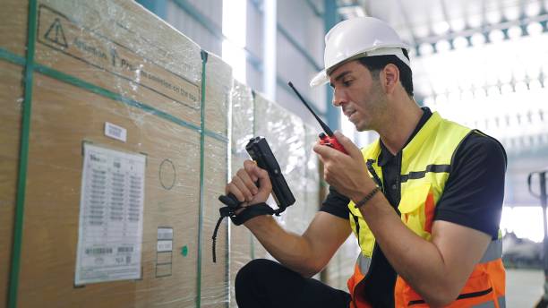 istock Professional young engineer man holding barcode scanner and radio communication talking with colleague to inspect the products in the factory Industrial 1480264432