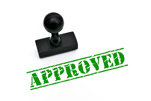 Approved printed in the green ink with wooden rubber stamp on the white background