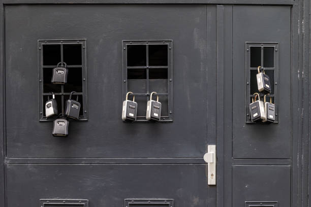 Too many house key padlocks on entrance door Ridiculous number of padlocks for self check-in homestay house rentals - entire residential building is rented for short stays creating housing problems in cities all over the world key package stock pictures, royalty-free photos & images
