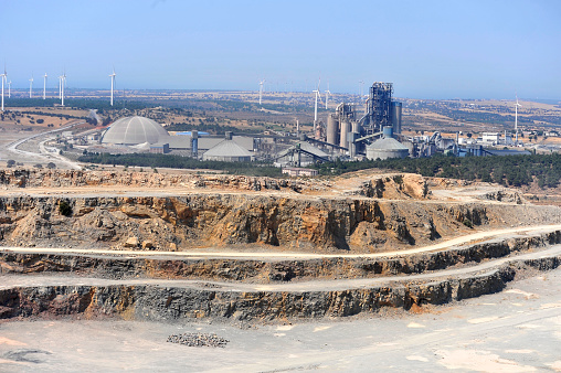 Open-pit mine, windmills and a factory