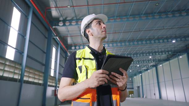 istock Professional caucasian male architect using tablet for work standing and looking around in factory Industrial 1480269024