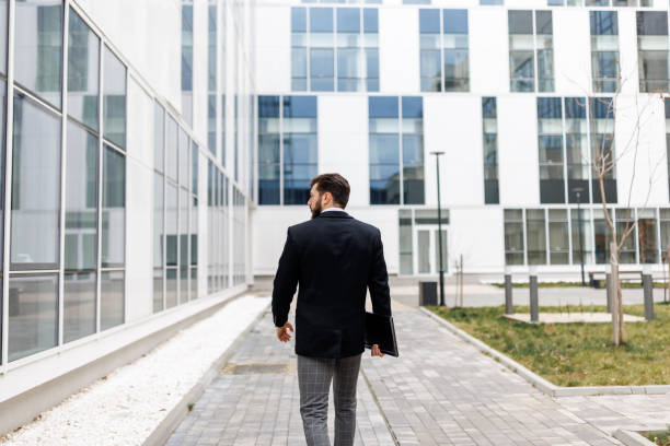 istock Back view of young businessman going to work 1480269310