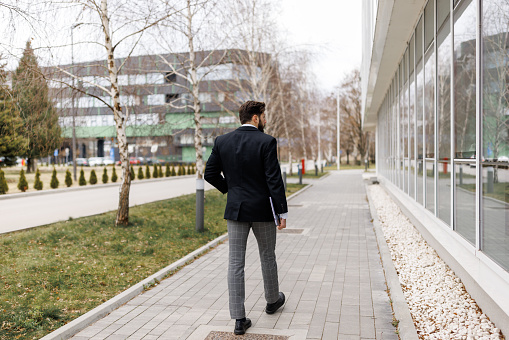 Back view of young businessman going to work