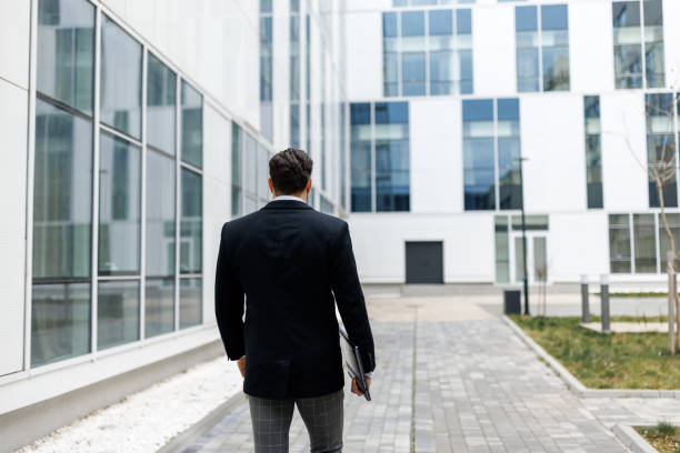 istock Back view of young businessman going to work 1480270323