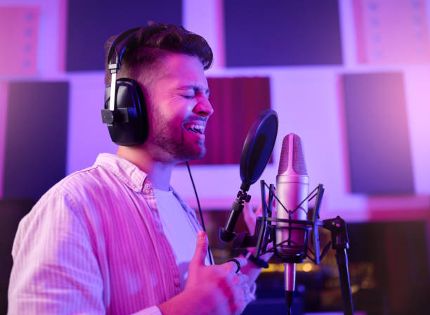 istock Musician, singer or man on neon microphone, karaoke studio or theatre practice in night booth recording. Singing, person or pop artist on production, voice media or sound performance in light theater 1480273676
