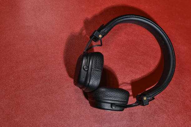 istock Wireless black headphones on a red background. View from above. 1480273796