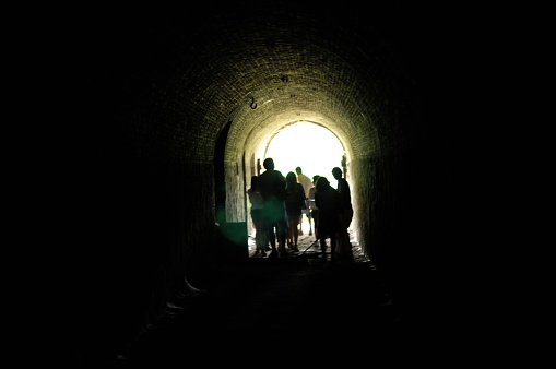 silhouette of people along a tunnel