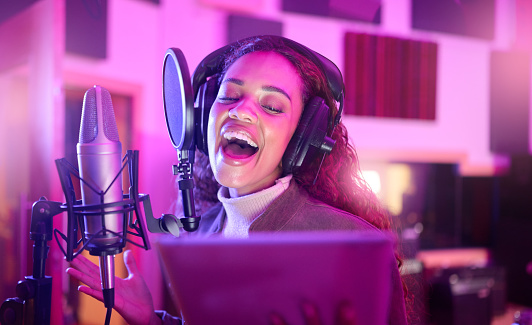 Technology, singing or musician on neon microphone, music studio lyrics or songwriting app in night recording. Singer, woman or artist on tablet in production, voice media or sound light performance
