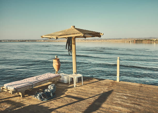 Sun umbrella and diving weights on a diving pier platform, color toning applied,  Egypt.