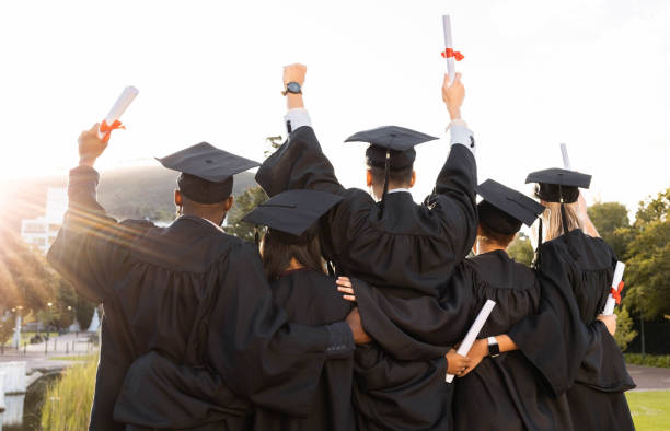 Graduation, group and back view of students celebrate education success. Behind of excited graduates at campus celebration for study goals, university award and learning motivation for happy future stock photo