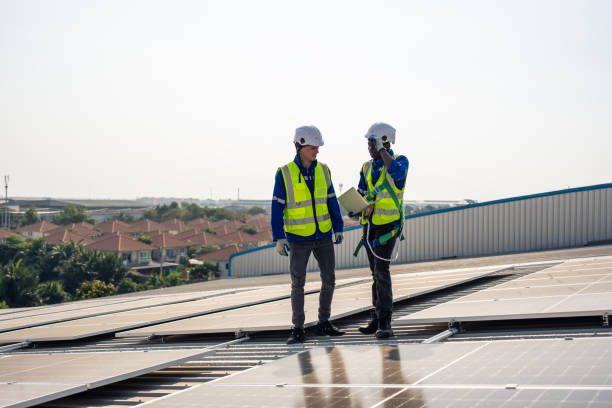 istock Professional engineer work to maintenance of photovoltaic panel system. Attractive technician worker working on roof inspect and check solar cell panels equipment box at solar cell field during sunset 1480277702