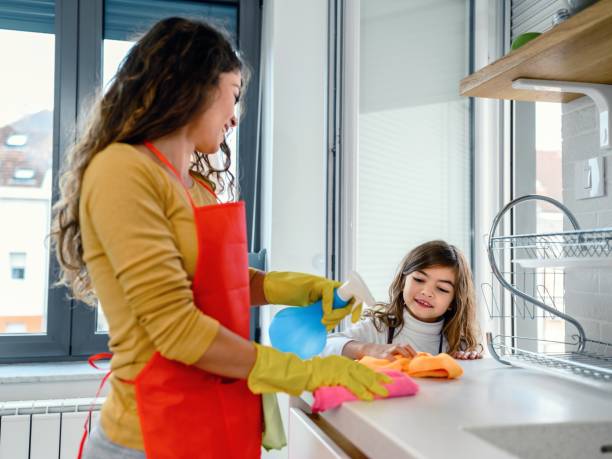 istock Mother and daughter cleaning kitchen counter 1480278548