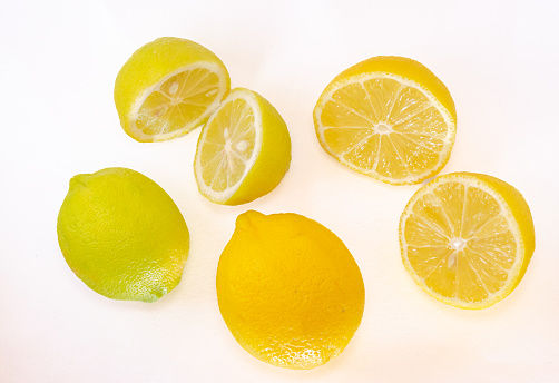 Two whole yellow lemon fruits, and two halved ones isolated in white background.