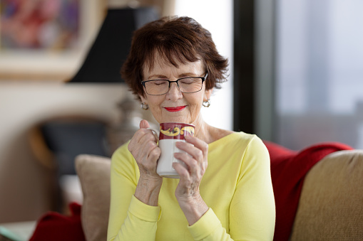Senior woman sitting at home drinking tea.