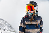 Portrait of sportswoman wearing helmet and mask looking away enjoying frosty day perfect day for snowboarding or skiing