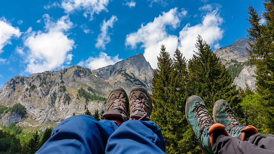 People showing the hiking boots with panoramic view on the mountains of Hochschwab Region in Upper Styria, Austria. Sharp summit of Zinken in the beautiful Alps in Europe. Concept freedom tourism