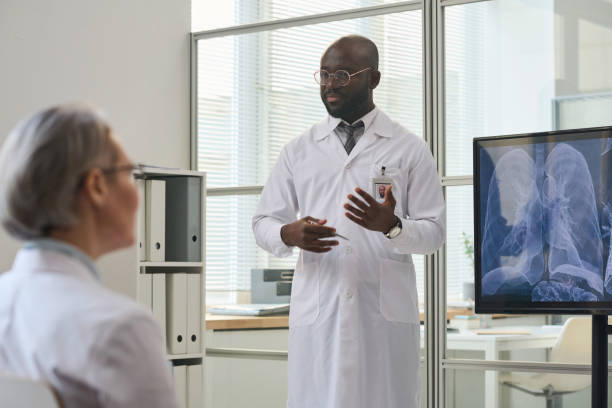 istock Doctor presenting x-ray image of lungs to his colleagues 1480286116