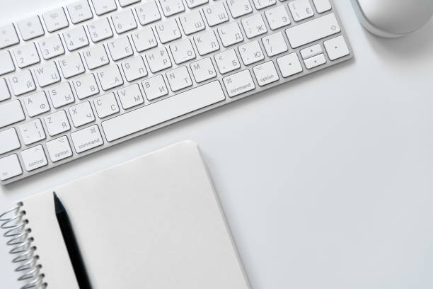 istock Office table desk. Workspace with sketchpad, keyboard, office supplies, pencil, on white table. 1480286178