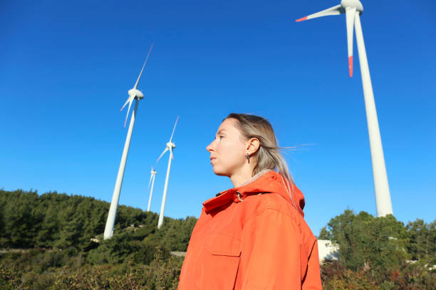 istock Woman admiring wind farm turbines 1480286986