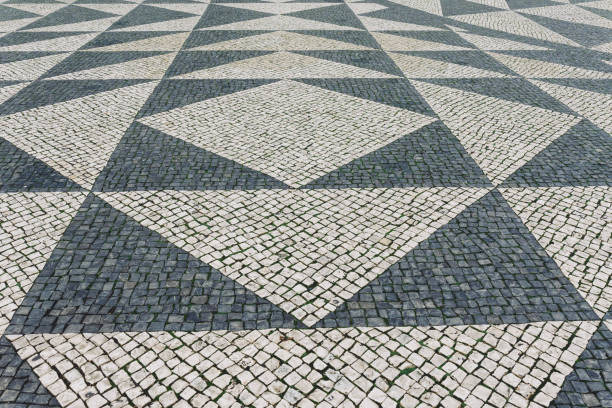 sol en briques de tuiles à lisbonne, portugal. mosaïque traditionnelle de type ancien sur le trottoir ou le trottoir en ville - paving stone cobblestone road old photos et images de collection