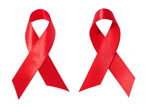 A silk red ribbon in the form of a bow is isolated on a white background, a symbol of the fight against AIDS and a sign of solidarity and support.