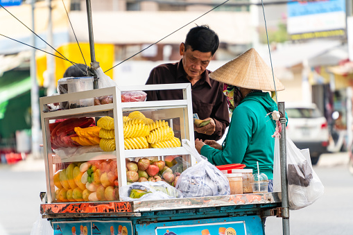 Ho Chi Minh City, Vietnam - December 24, 2022: selling snacks and fruits on the streets of Vietnam. One of the street culture in this country. Selective focus