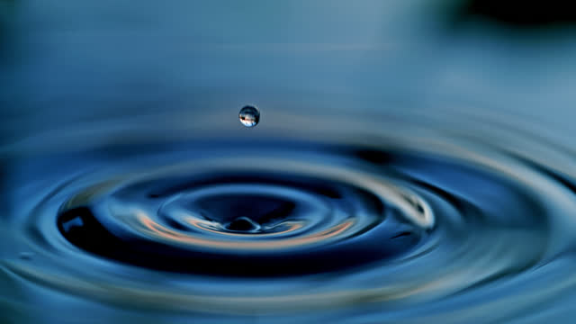Drop of water falling on water surface creating another droplet