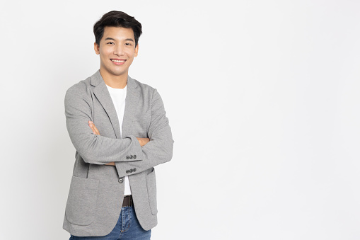Young Asian businessman smiling with arms crossed isolated on white background