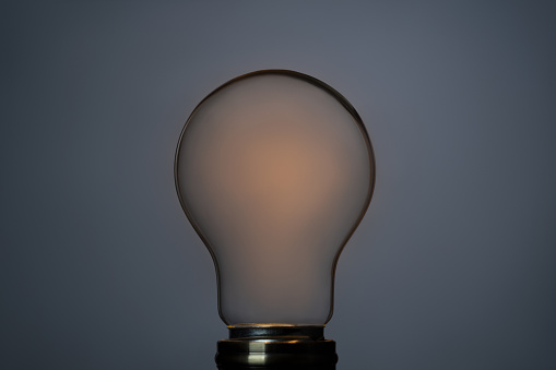 Abstract concept with empty classic light bulb in the dark. This file is cleaned and retouched.