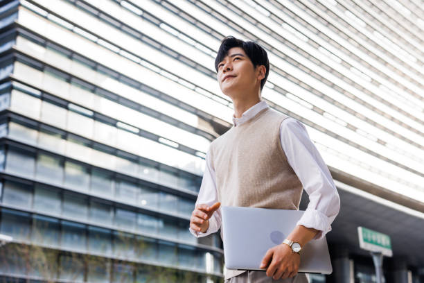 istock white-collar workers walking with laptops in their arms 1480293353