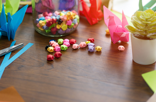 Stars and birds folded from colorful origami paper as a gift or a festive decoration of happiness and hope on a wooden table. with copy space